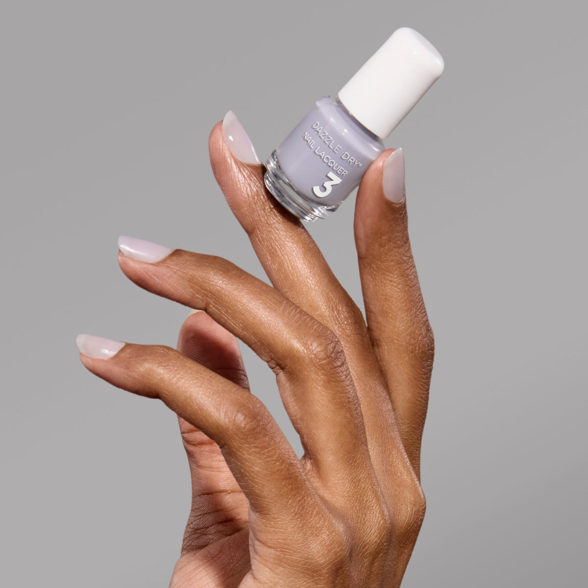 Hand with Fresh Start painted on nails holding mini nail lacquer bottle.