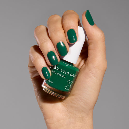 Hand with Don't Be Jaded painted on nails holding lacquer bottle