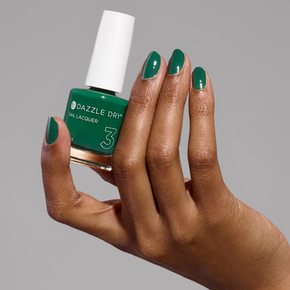 Hand with Don't Be Jaded painted on nails holding lacquer bottle