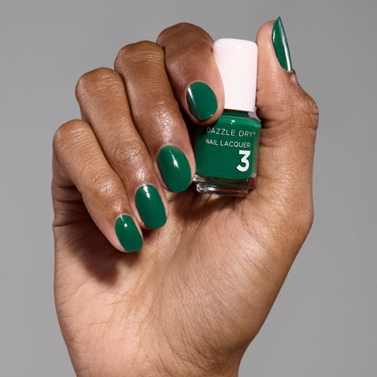 Hand with Don't Be Jaded painted on fingernails holding mini nail polish bottle