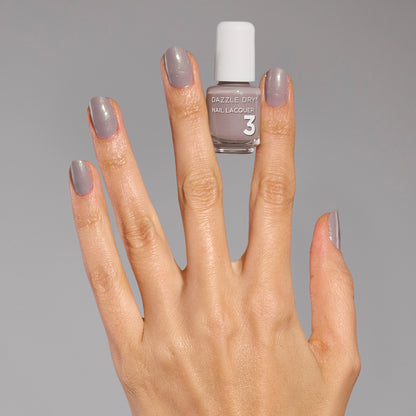 Hand with Let's Glow painted on fingernails holding mini nail polish bottle