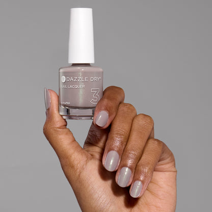 Hand with Let's Glow painted on nails holding lacquer bottle