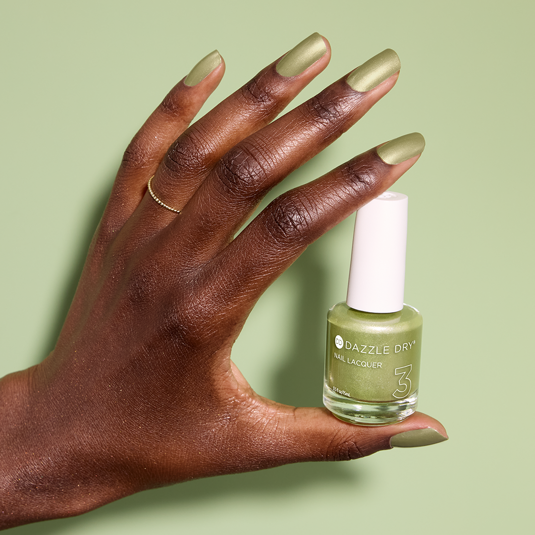 Hand with Lucky Me painted on nails holding lacquer bottle