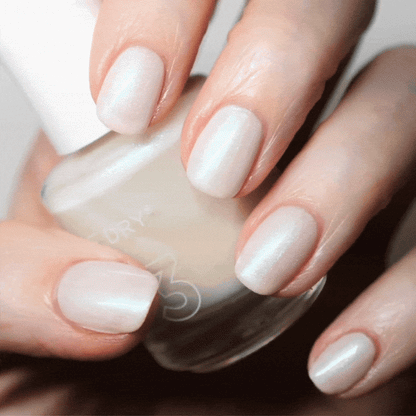 Hand with Artisan painted on nails holding lacquer bottle
