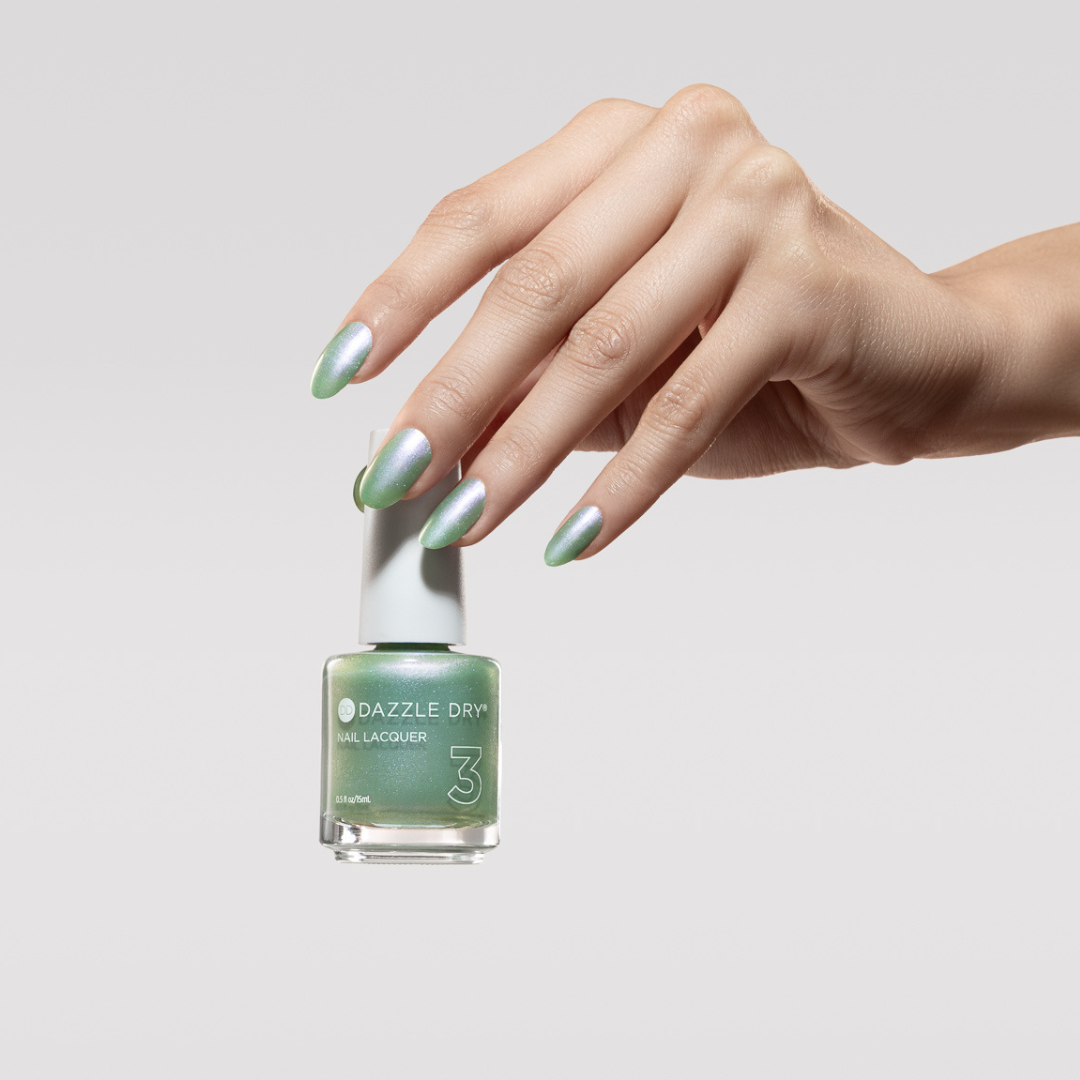 Hand with Aurora painted on nails holding lacquer bottle