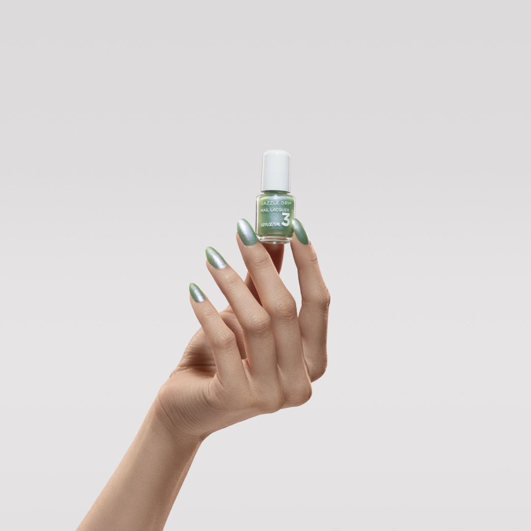 Hand with Aurora painted on nails holding mini lacquer bottle