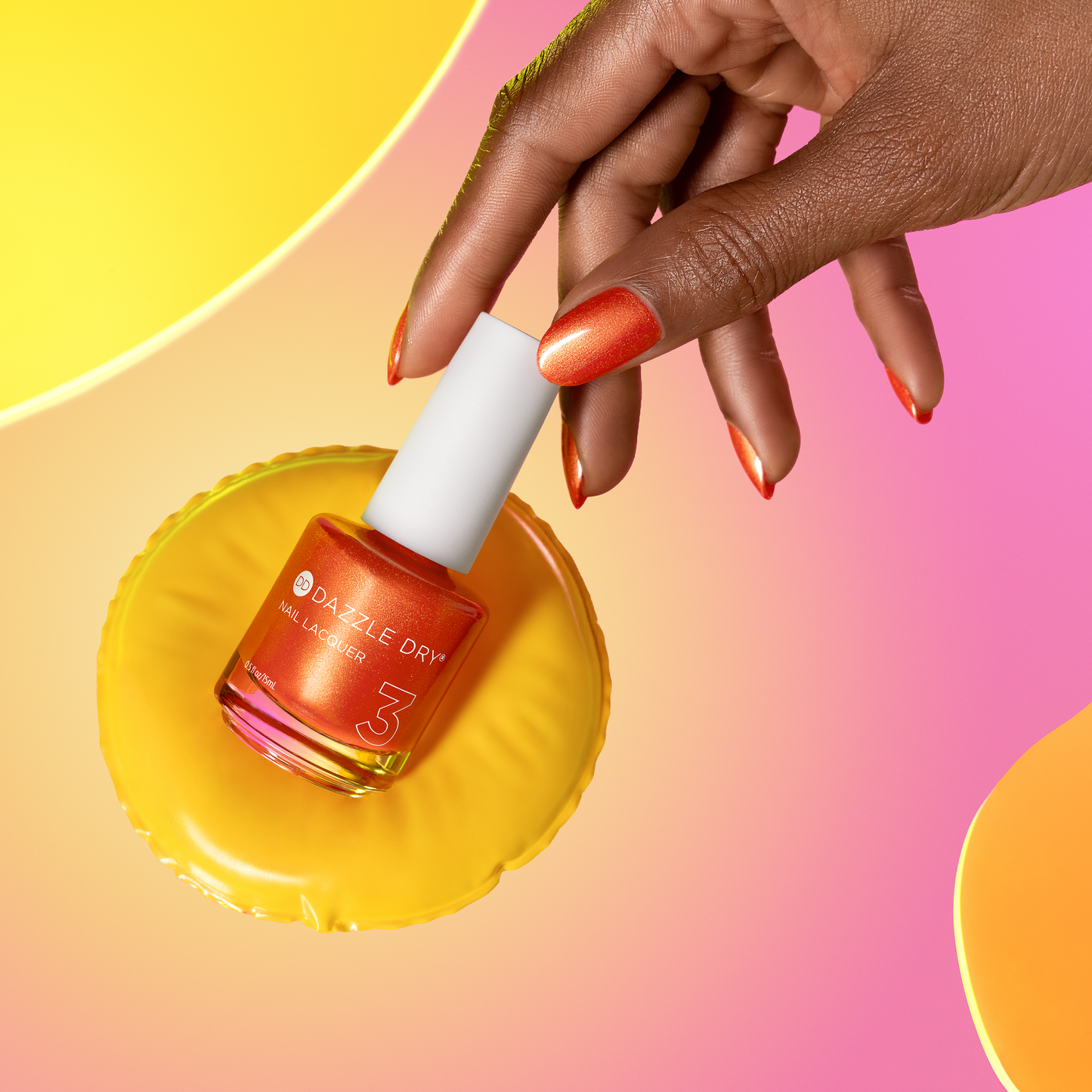 Hand applying orange nail polish from a bottle labeled 'Dazzle Dry' on a colorful background