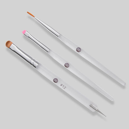 Set of makeup brushes with clear handles on a light gray background