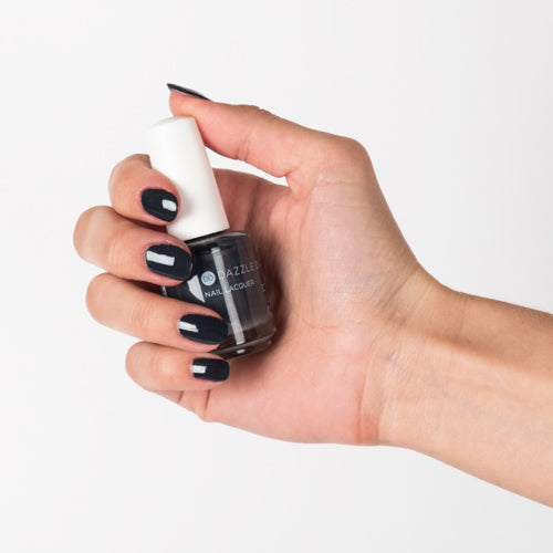 Hand with Joan's Armor painted on nails holding lacquer bottle