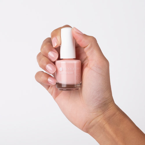 Hand with Livin' La Vida Yoga painted on nails holding lacquer bottle