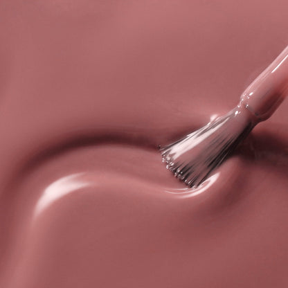 A close-up of a glossy mauve-pink liquid swatch with a brush stroke applying the color.