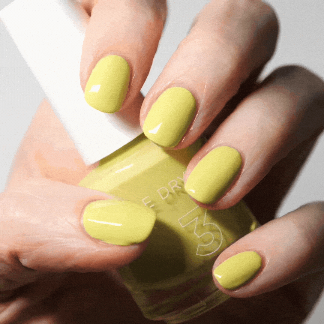 Hand with Fresh Squeezed painted on nails holding lacquer bottle