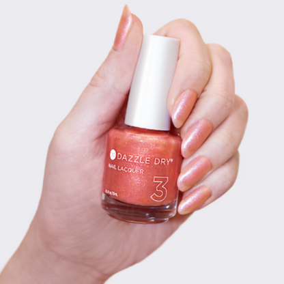 Hand with Heart of Gold painted on nails holding lacquer bottle