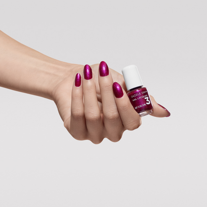 Hand with In Orbit painted on nails holding mini lacquer bottle