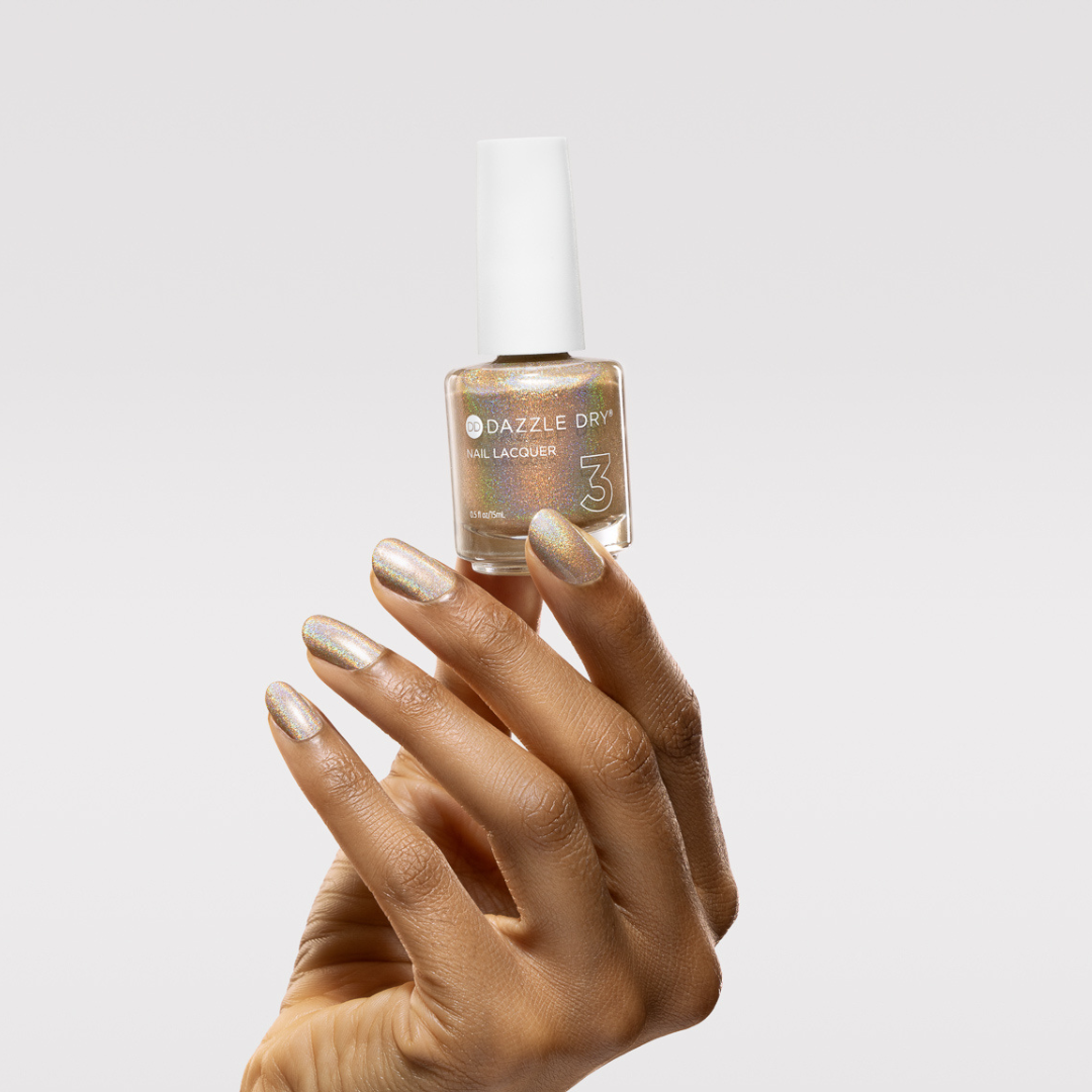 Hand with Light-Year painted on nails holding lacquer bottle