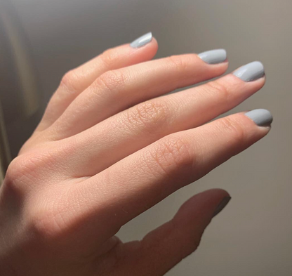 Hand with Tranquil Gray painted on nails