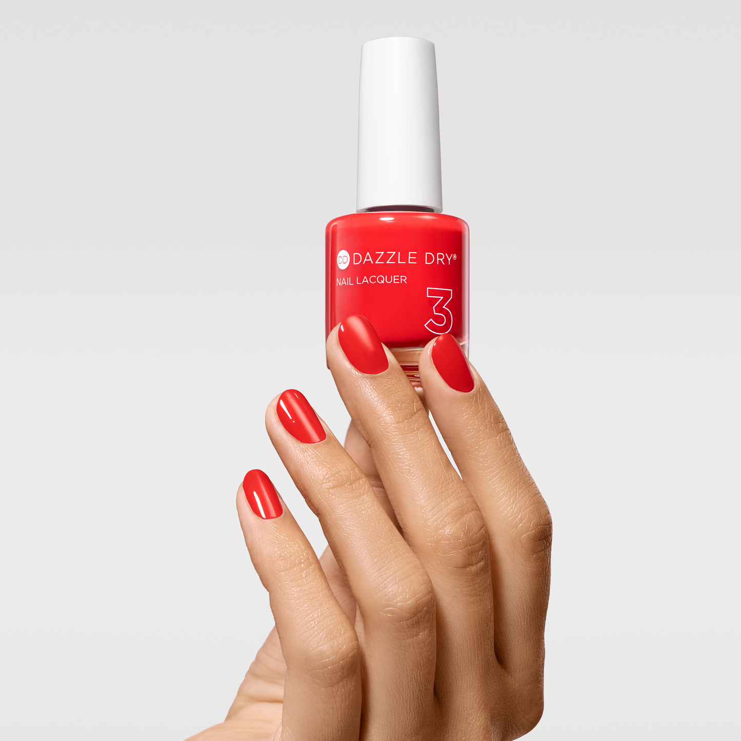 Hand with Spark painted on nails holding lacquer bottle
