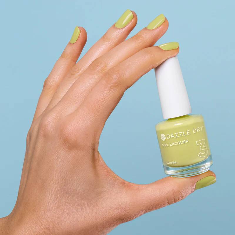 Hands with nails painted in Dazzle Dry Freshly Squeezed holding full-size yellow lacquer.