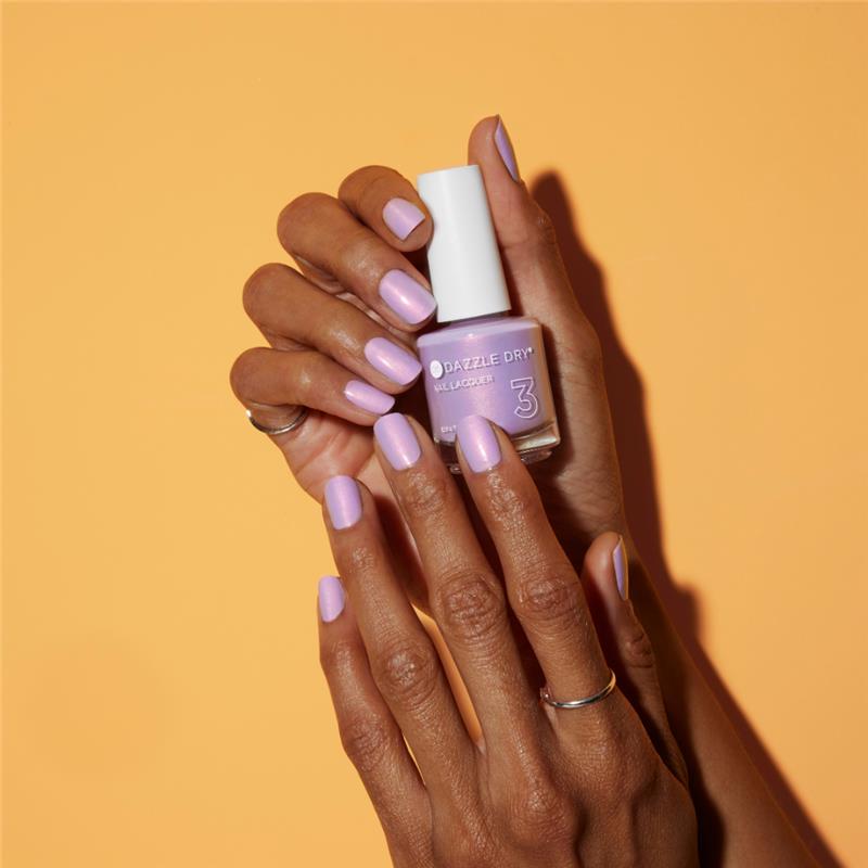 Hands with Lovely Lilac painted on nails holding lacquer bottle