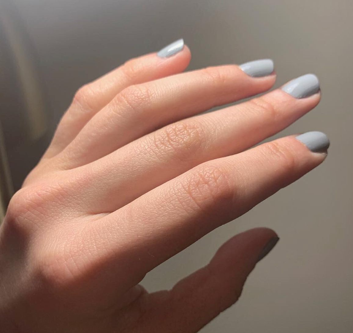 Hand with Tranquil Gray painted on nails